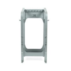 The Exxentric kBox Advanced Accessory Rack is a gray metal stand with a rectangular frame and logo near the top, featuring a sturdy, industrial design to support or hold objects.