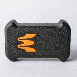 A black textured Enode Sensor with an orange W design, echoing the Enode Velocity Based Training logo, stands out on a white background.