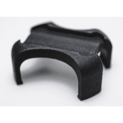 Close-up of the black, curved Enode Pro / Exxentric Flywheel Adapter, a small 3D-printed object with a textured surface and four arms, set against a sleek white background.